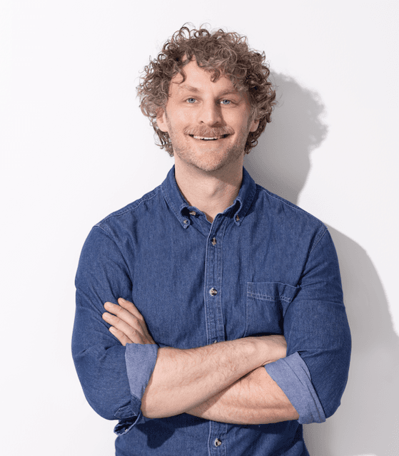 Headshot of Daniel Oschrin, smiling and wearing a blue shirt